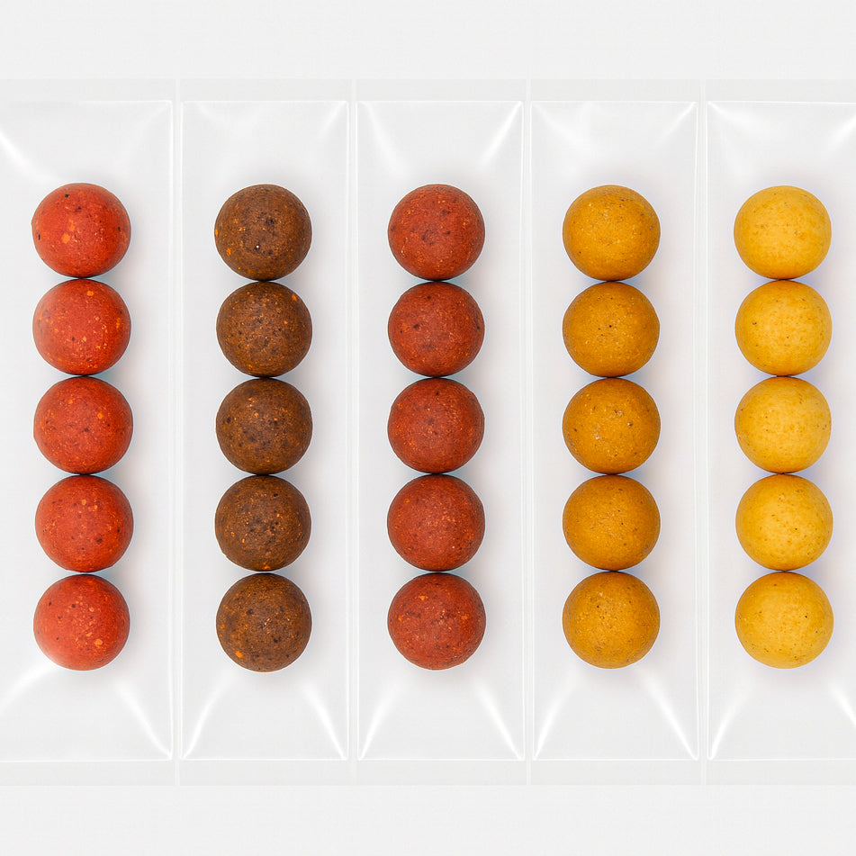 Sample pack of boilies in five flavours, neatly sealed in individual compartments of a clear vacuum pack against a white background.